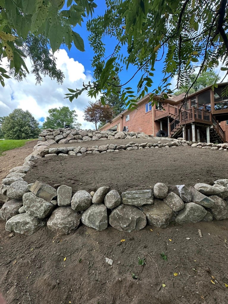 Tiered boulder retaining walls on a residential hillside